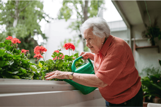 Oudere vrouw geeft planten op haar balkon water